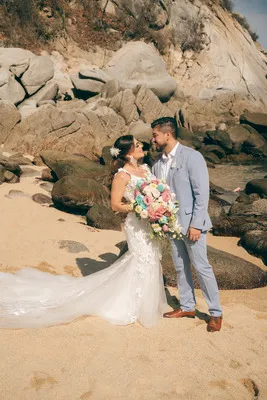 Pareja de recién casados posando en una playa rocosa durante su hermosa boda en Oaxaca, México.