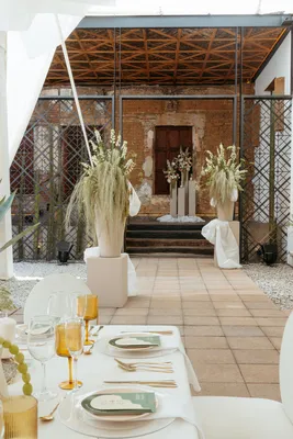 Decoración de mesa de lujo con detalles dorados y arreglos florales altos para una Destination Wedding en un patio.
